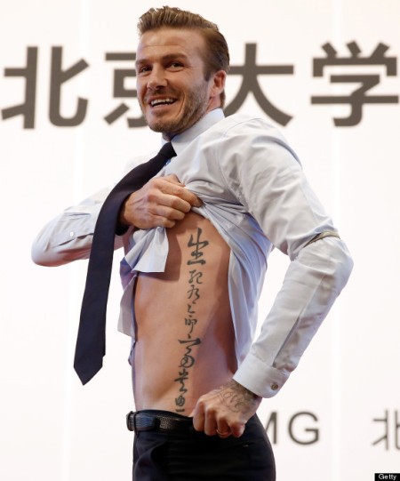 BEIJING, CHINA - MARCH 24: British football player David Beckham shows his tattoo to fans during his visit to Peking University on March 24, 2013 in Beijing, China. David Beckham is on a five-day visit to China at the invitation of the China Football Association as China's first international ambassador. (Photo by Lintao Zhang/Getty Images)